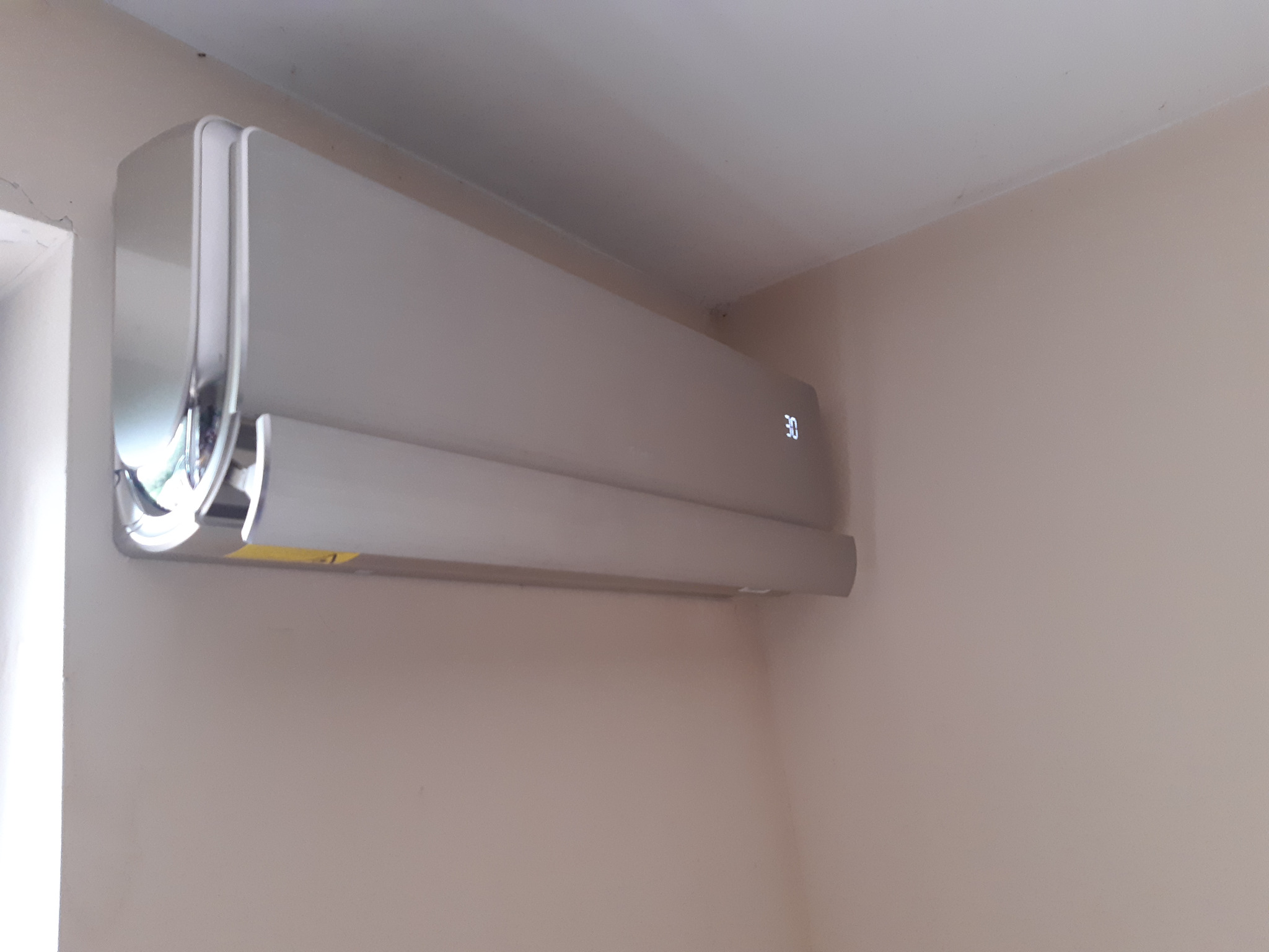 Zamontowany, nowoczesny klimatyzator z wyświetlaczem temperatury (30 stopni Celsjusza) na ścianie w Golędzinowie, model u-crown.