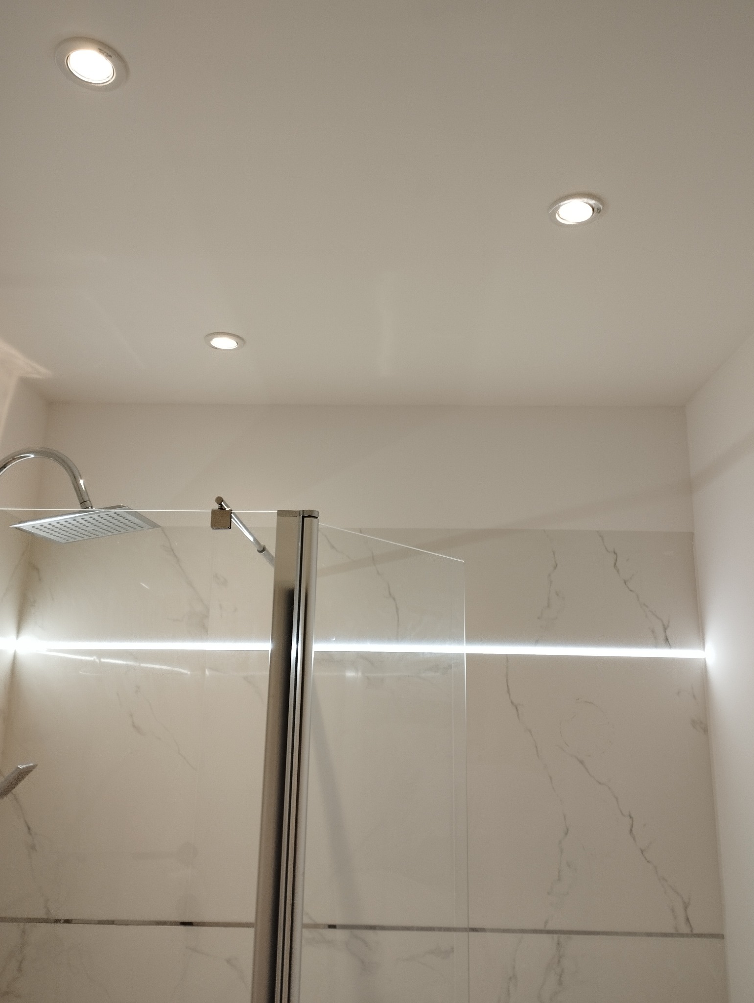 Kabina prysznicowa z marmurowymi płytkami i oświetleniem LED w Ostrowcu Świętokrzyskim. Nowoczesny design, chromowane wykończenia i minimalistyczny styl.