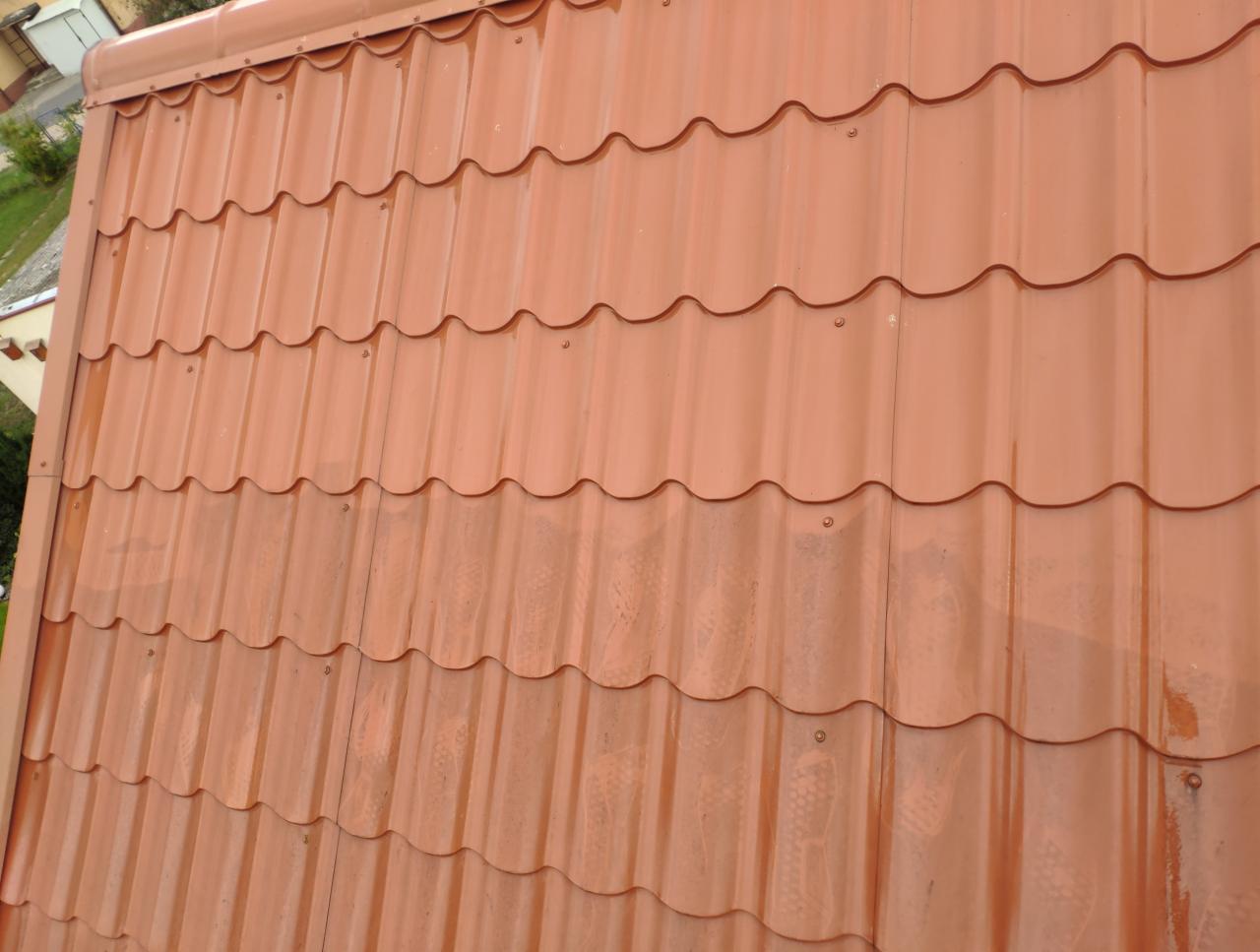 Czerwono-brązowa blachodachówka ułożona na dachu w Pułtusku, widoczne ślady po deszczu.