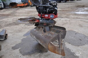 Szczegółowy widok łyżki koparki z zamontowanym obrotowym chwytakiem, używanej do prac ziemnych w Barczewie. Widoczne ślady użytkowania i błoto na łyżce.