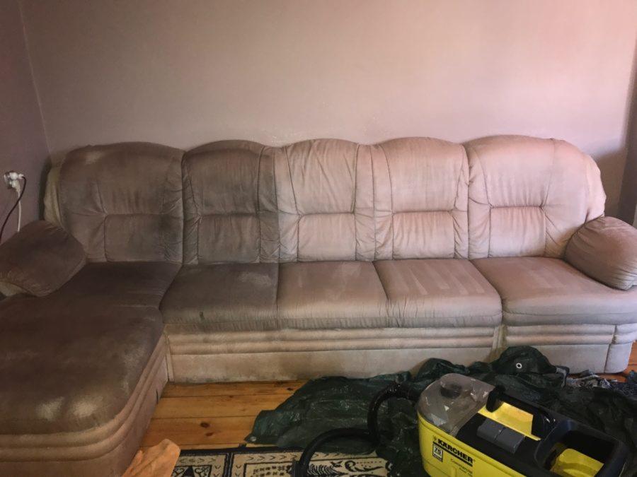 Beżowa narożna kanapa z widoczną różnicą w czystości tapicerki, połowa wyczyszczona, obok żółty odkurzacz piorący Karcher Z8 i folia ochronna.