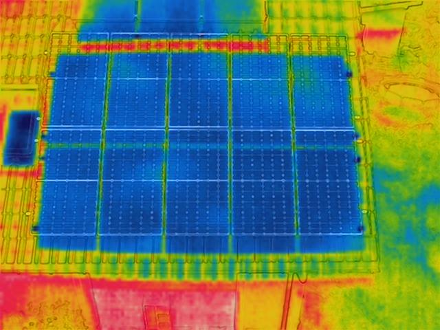 Termowizja instalacji paneli słonecznych na dachu, widoczne rozkłady temperatur w różnych kolorach.