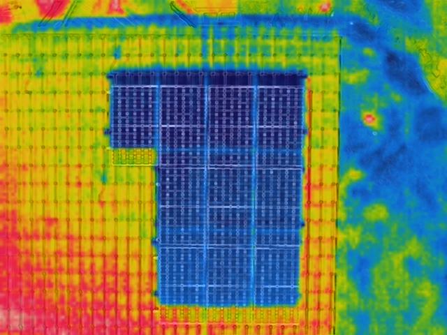 Termowizja paneli słonecznych na dachu budynku, ukazująca rozkład temperatur w różnych obszarach instalacji.