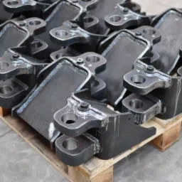 Stalowe, spawane elementy konstrukcyjne na drewnianej palecie, widoczne ślady spawania i obróbki.