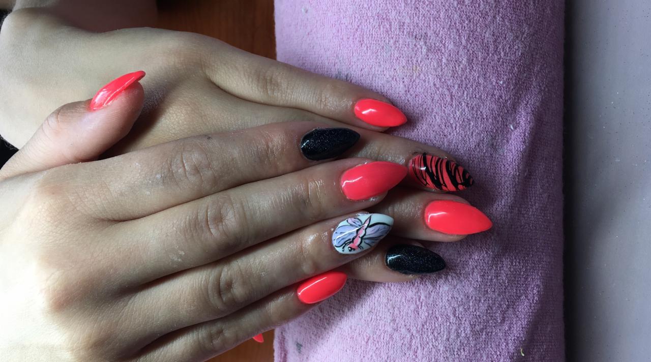 Dłonie z pomalowanymi paznokciami w kolorach: neonowy róż, czarny brokat oraz biały z motywem motyla i czarnymi paskami, ułożone na fioletowym ręczniku.