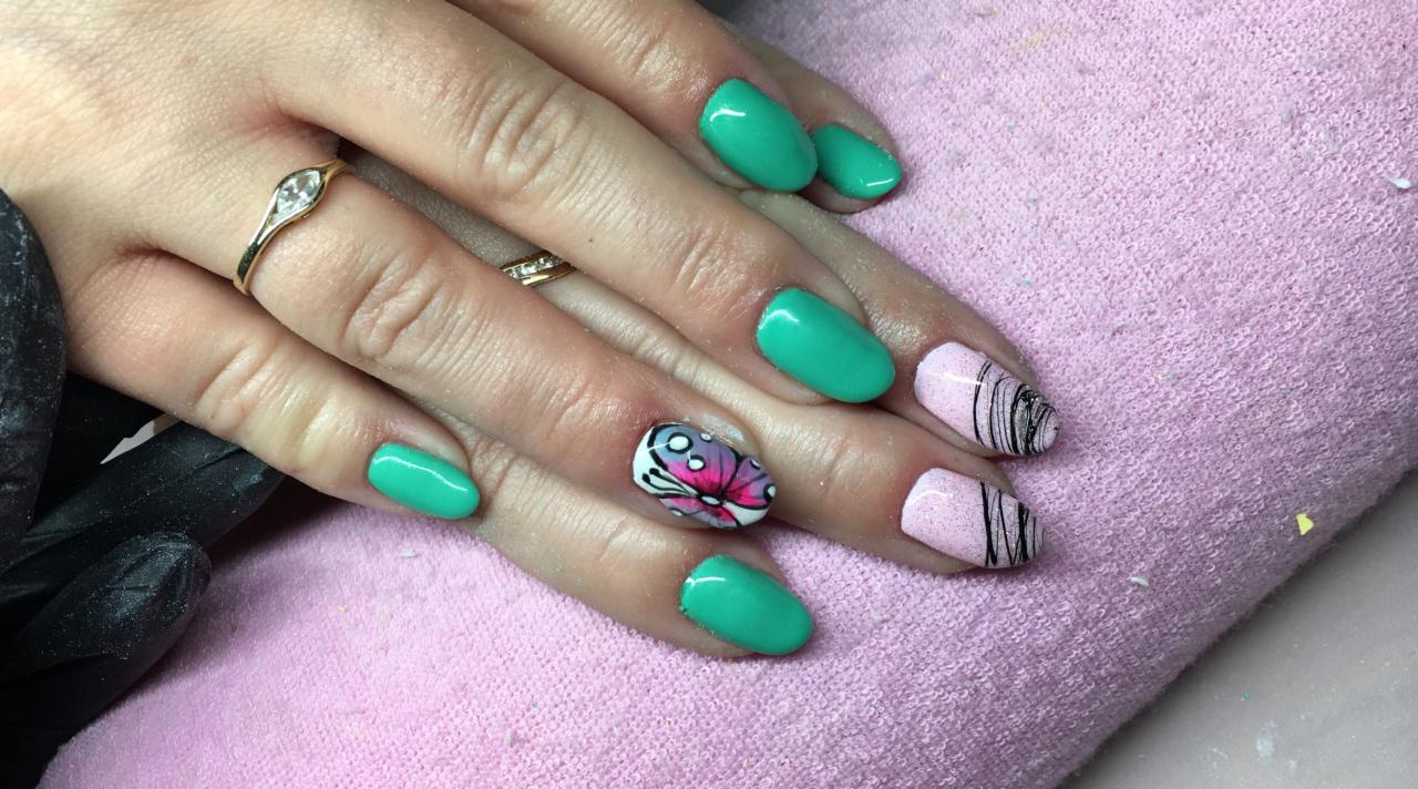 Dłonie z pomalowanymi paznokciami: trzy w kolorze turkusowym, jeden z motywem motyla i dwa jasnoróżowe z czarnymi liniami, na tle różowego ręcznika, z pierścionkami na palcach.