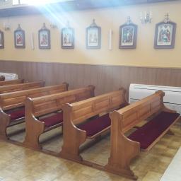 Ekoklimat - Wnętrze kościoła z drewnianymi ławkami i zamontowaną jednostką klimatyzacyjną na ścianie, oświetloną światłem słonecznym wpadającym przez okno.