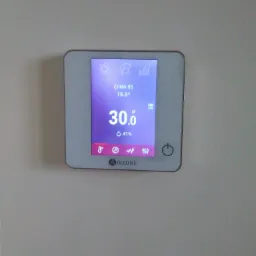 Panel sterowania klimatyzacją Airzone z wyświetlaną temperaturą 30 stopni Celsjusza i wilgotnością 41% zamontowany na ścianie.