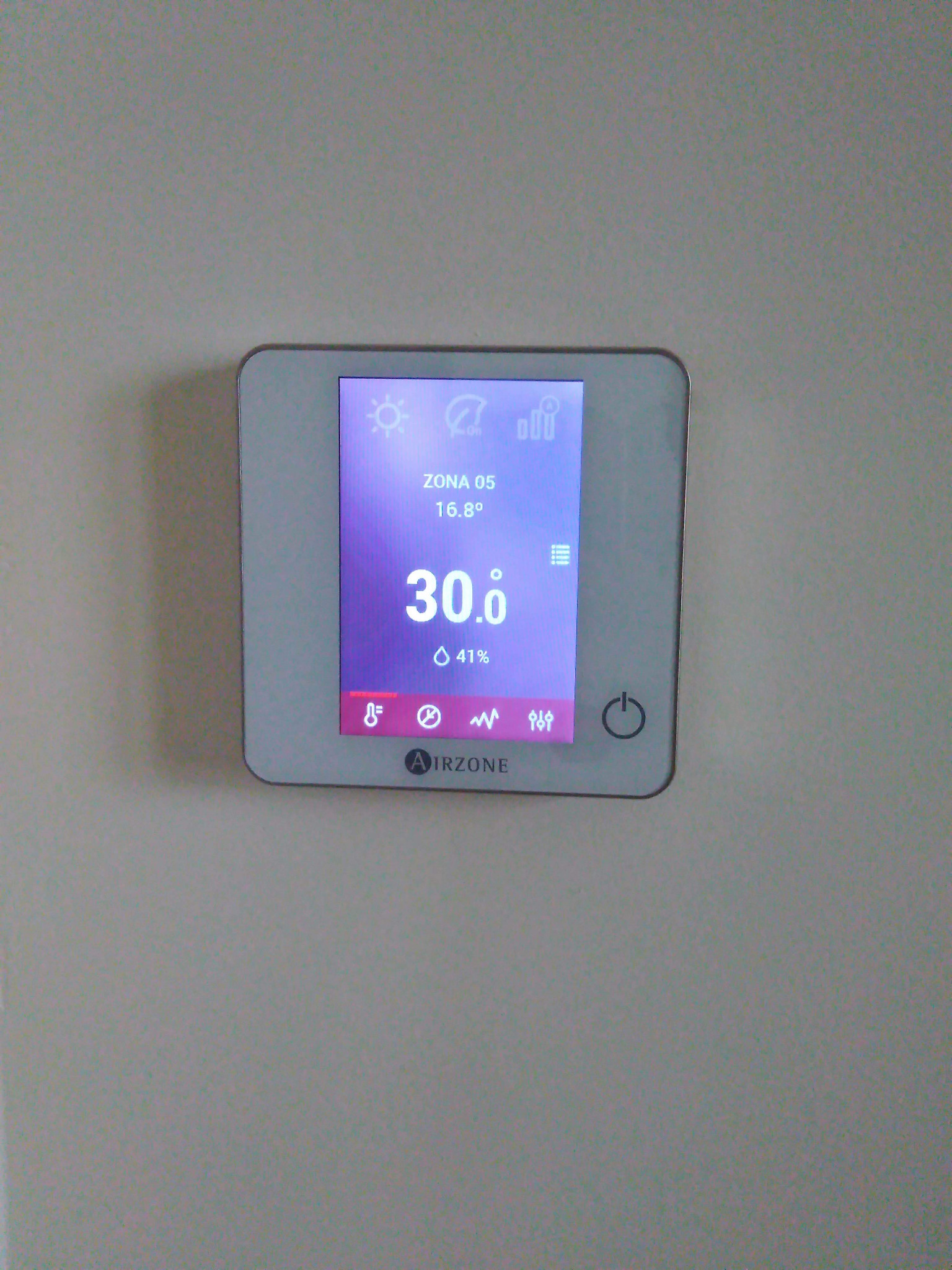 Panel sterowania klimatyzacją Airzone z wyświetlaną temperaturą 30 stopni Celsjusza i wilgotnością 41% zamontowany na ścianie.