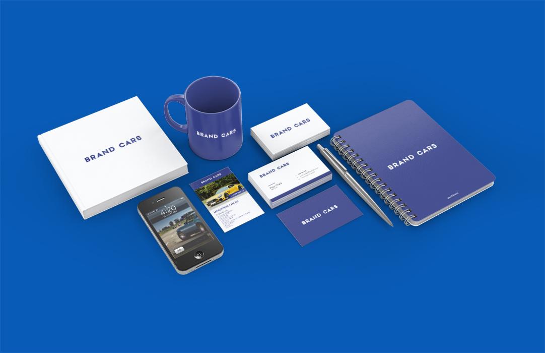 Makieta identyfikacji wizualnej marki samochodowej: wizytówki, notatnik, kubek, broszura, telefon z widoczną stroną internetową, długopis, wszystko w kolorze niebieskim na jednolitym niebieskim tle.