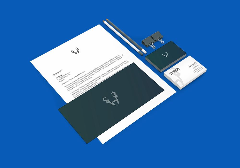 Makieta identyfikacji wizualnej firmy z logo na papierze firmowym, wizytówce i teczce, ułożona na niebieskim tle z ołówkami i klipsami.