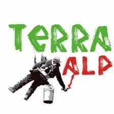 Sylwetka mężczyzny w uprzęży alpinistycznej, trzymającego wiadro i narzędzie, na tle napisu 'TERRA ALP' w kolorach zielonym i czerwonym, sugerująca prace na wysokościach.