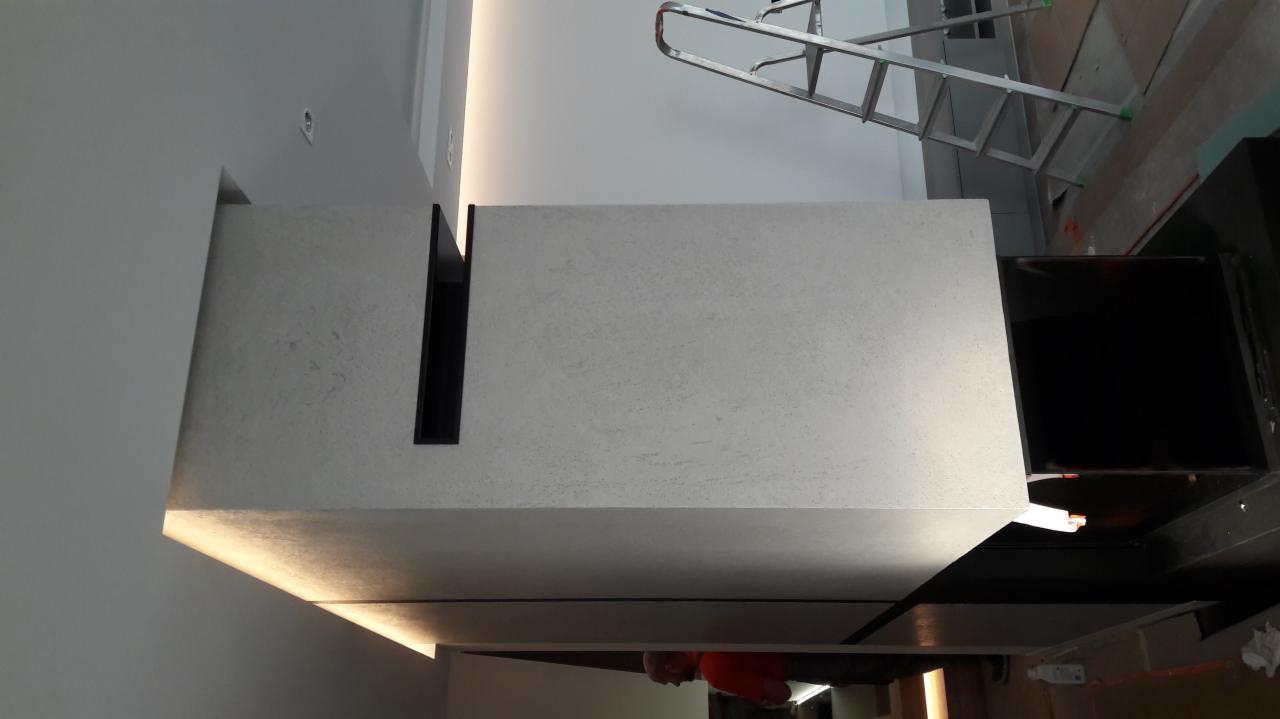 Nowoczesny sufit podwieszany z oświetleniem LED i czarnymi wnękami, widoczna drabina malarska w tle.