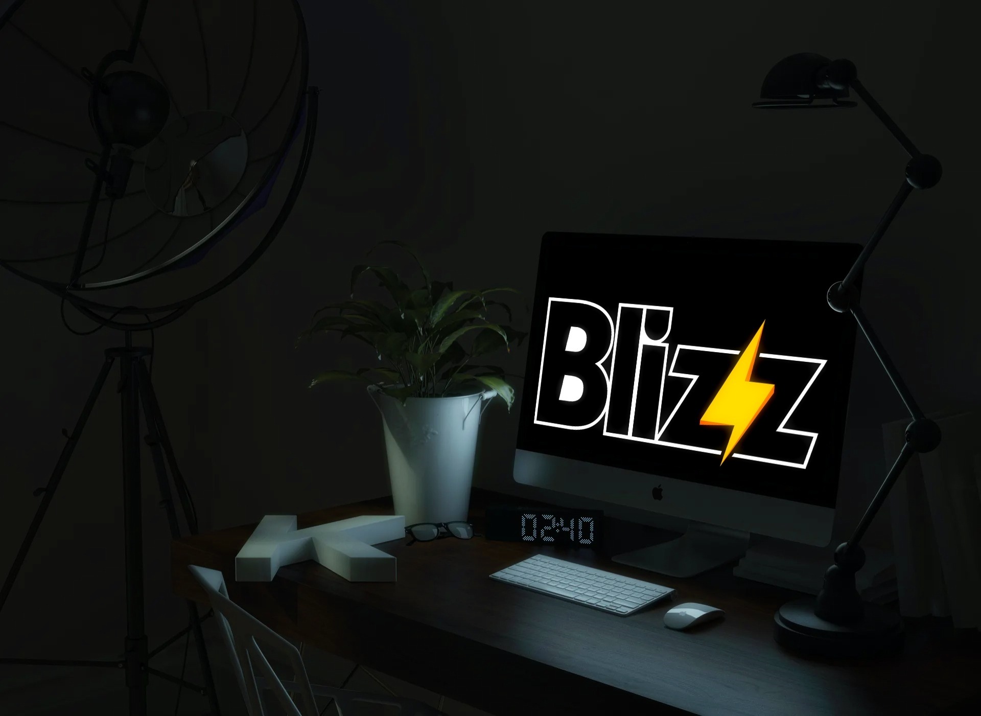 Biurko z komputerem wyświetlającym logo Blizz z żółtą błyskawicą, obok roślina w białej doniczce, okulary i cyfrowy zegar.