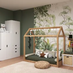 Wizualizacja pokoju dziecięcego z łóżkiem w kształcie domku oświetlonym girlandą, zielonymi ścianami, tapetą z motywem drzew i roślin, białymi meblami do przechowywania oraz pufem na beżowym dywanie.