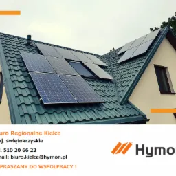 Instalacja paneli słonecznych na dachu domu z zieloną dachówką, widoczny komin i dwa okna. Na dole zdjęcia dane kontaktowe firmy Hymon.