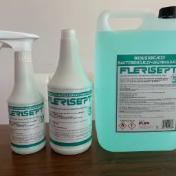 Trzy pojemniki z płynem do dezynfekcji Flerisept: butelka z rozpylaczem, butelka z zakrętką i kanister 5L, wszystkie z etykietą informującą o właściwościach wirusobójczych, bakteriobójczych...