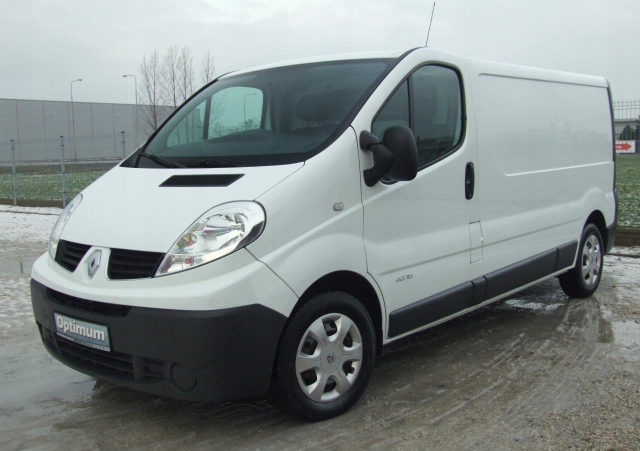 Biały samochód dostawczy Renault Trafic na mokrym placu, z widocznym logo 'Optimum' na przednim zderzaku.