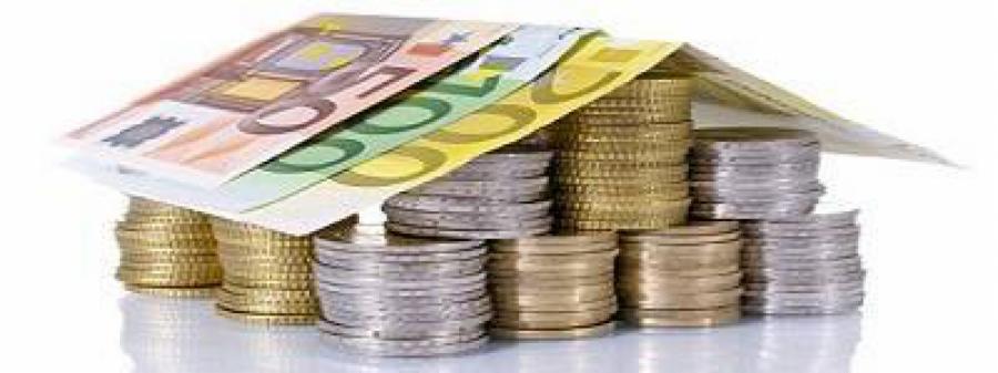 Symboliczny dom z monet i banknotów euro, na białym tle. Koncepcja finansowa, oszczędności na mieszkanie lub inwestycji.