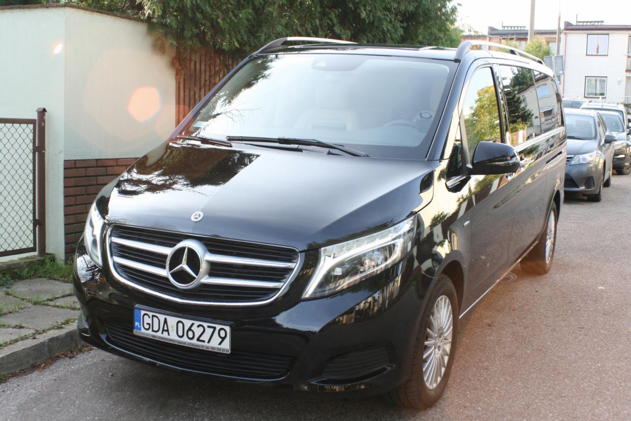 Czarny Mercedes V-klasa zaparkowany na ulicy, widoczne tablice rejestracyjne GDA 06279 i budynki w tle.