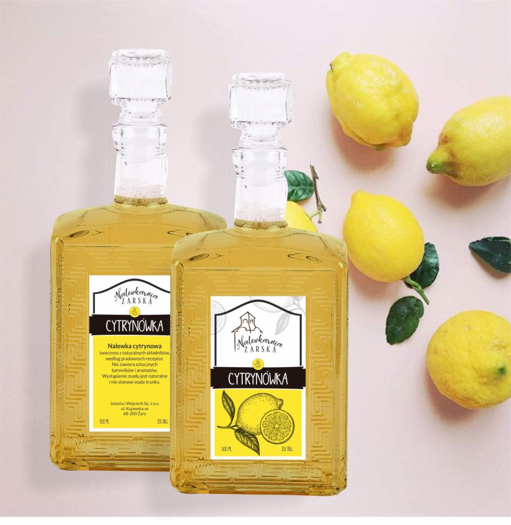 Dwie butelki cytrynówki 'Nalewkarnia Żarska' na różowym tle, otoczone świeżymi cytrynami. Butelki mają kwadratowy kształt i przezroczyste, kryształowe korki. Etykieta z rysunkiem cytryny.