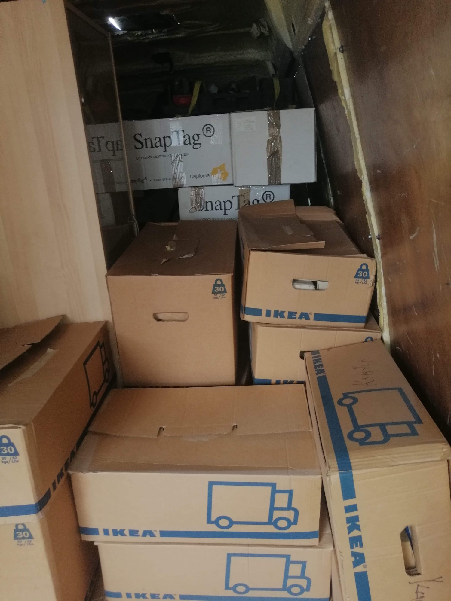 Wnętrze przestrzeni ładunkowej wypełnione kartonami, głównie marki IKEA z nadrukowanym niebieskim symbolem ciężarówki, oraz kartony SnapTag, widoczne oznaczenia wagi 30 kg.