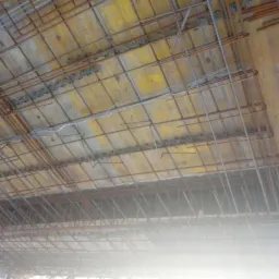 Zbrojenie stropu na deskowaniu szalunkowym, widok od dołu, przygotowane do zalania betonem.