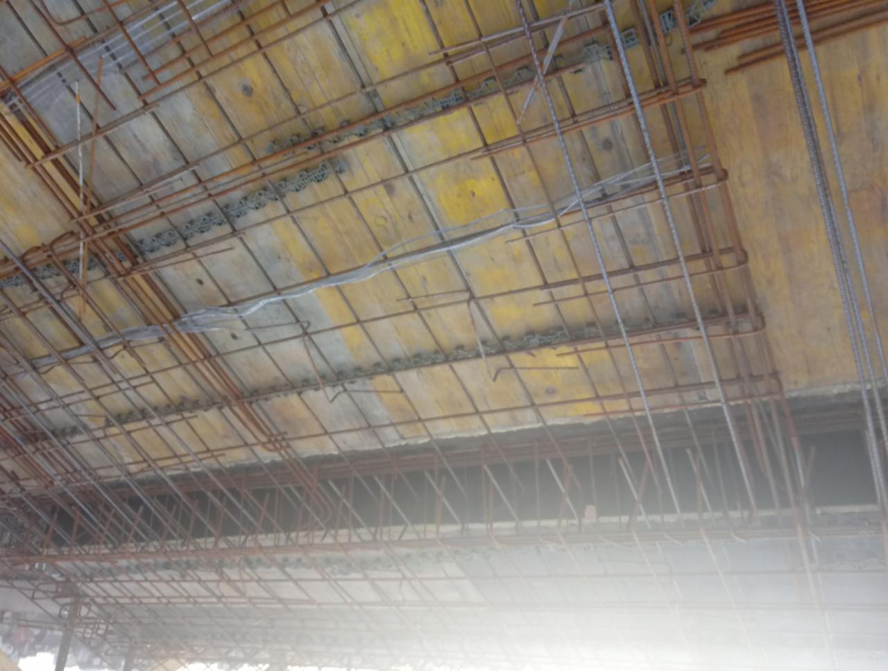 Zbrojenie stropu na deskowaniu szalunkowym, widok od dołu, przygotowane do zalania betonem.