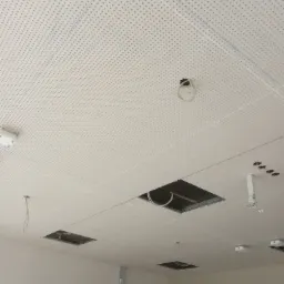Perforowany sufit podwieszany z płyt karton-gips z widocznymi otworami na oświetlenie i instalacje, w trakcie montażu w Bystrzycy Kłodzkiej.