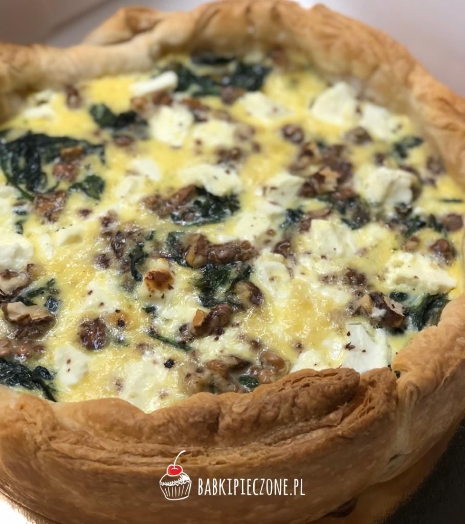 Quiche ze szpinakiem, serem feta i orzechami włoskimi w kruchym cieście, widoczne logo firmy na dole zdjęcia.