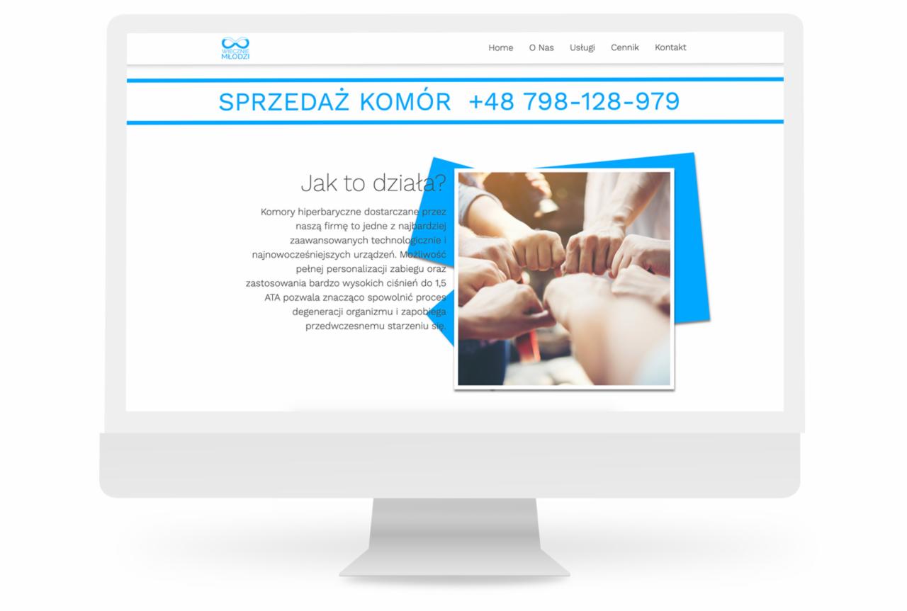 Ekran monitora wyświetlający stronę internetową z nagłówkiem 'Sprzedaż Komór' i zdjęciem zjednoczonych dłoni, promującą komory hiperbaryczne i spowalnianie procesów starzenia.