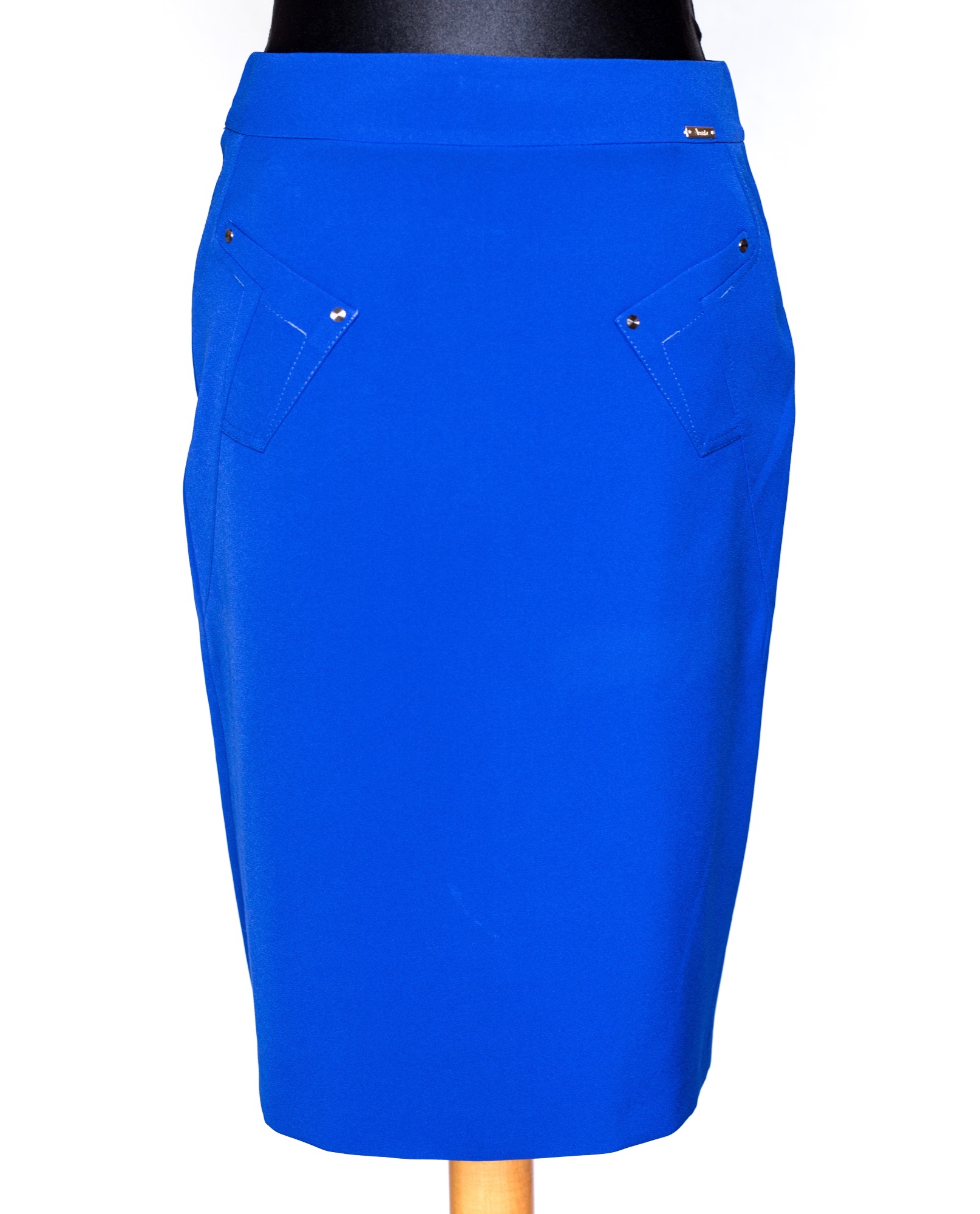 Kobaltowa spódnica ołówkowa z imitacją kieszeni, ozdobiona srebrnymi nitami, prezentowana na manekinie na białym tle.