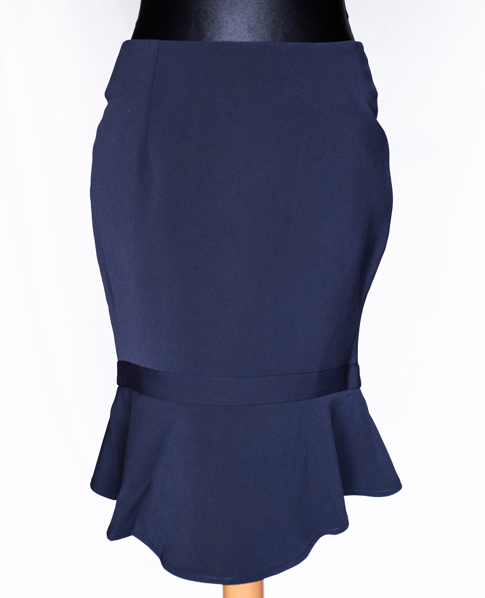 Granatowa spódnica ołówkowa z baskinką, zaprezentowana na manekinie na białym tle.