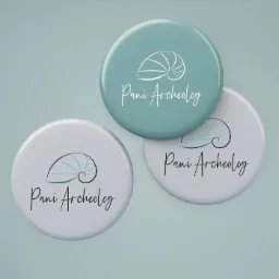 Trzy okrągłe przypinki z logo firmy 'Pani Archeolog', dwie szare i jedna turkusowa, na gładkim, jasnoniebieskim tle.