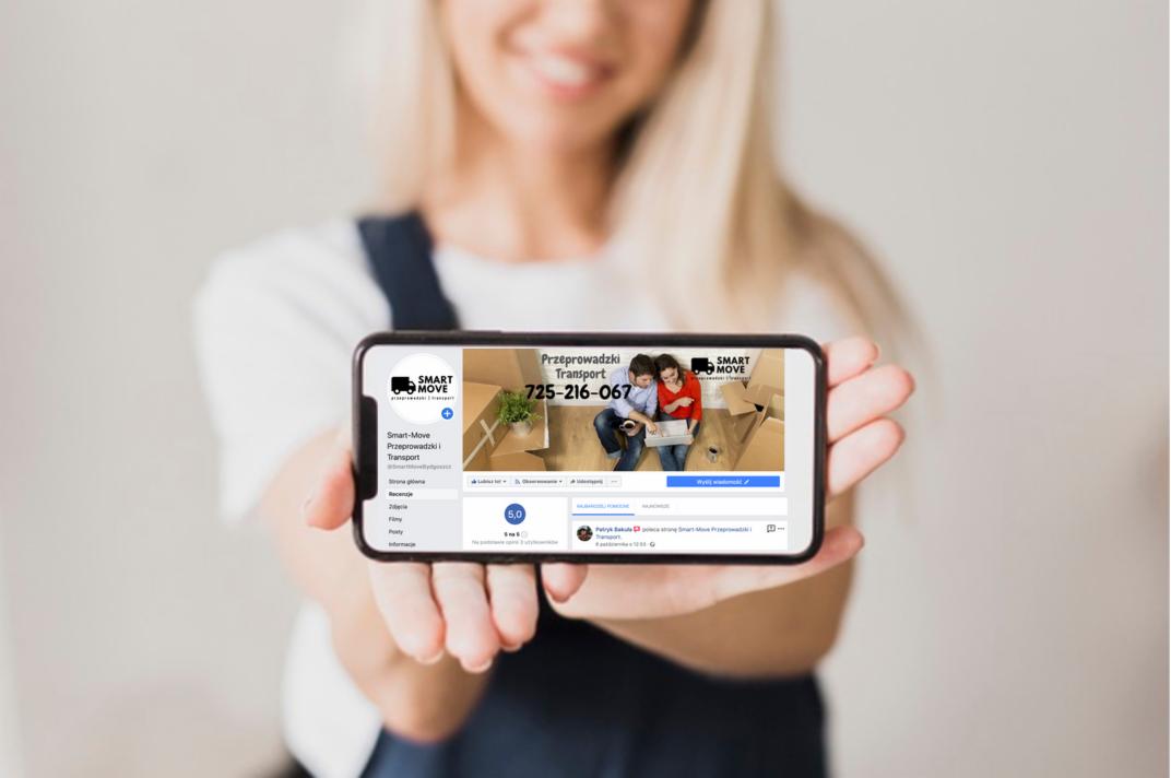Kobieta prezentuje na smartfonie profil firmy przeprowadzkowej Smart Move z widocznym numerem telefonu i zdjęciem pary planującej przeprowadzkę.
