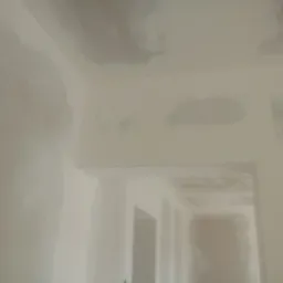 Ściany po gładzi w Tuliszkowie. Widoczne ślady po nałożeniu gładzi szpachlowej na ścianach i suficie, gotowe do szlifowania i malowania.