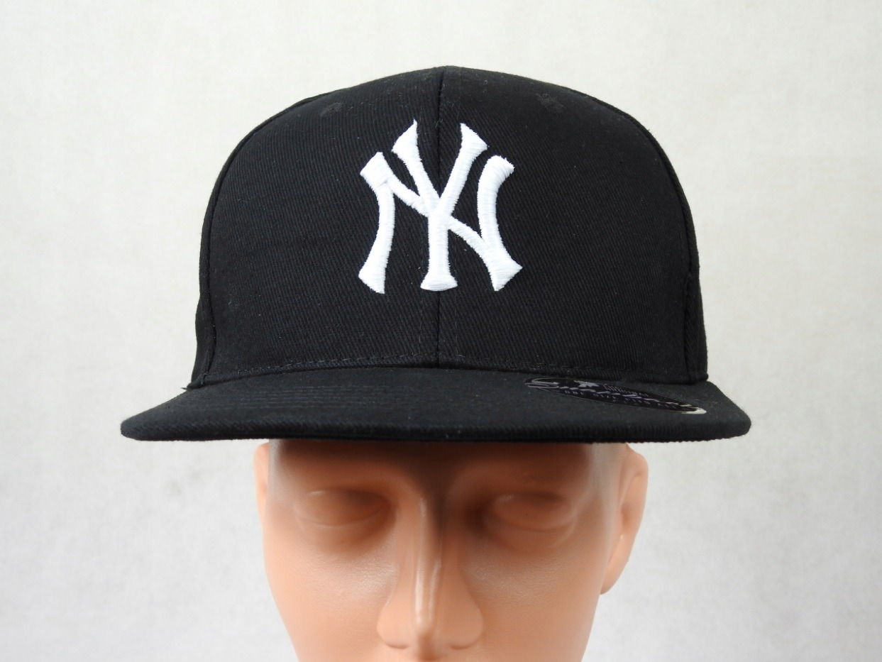Czarna czapka typu full cap z białym, haftowanym logo NY, umieszczona na manekinie z widoczną fakturą materiału i delikatnym połyskiem nici.