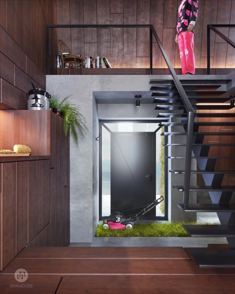 Wnętrze domu z drewnianą zabudową, schodami ażurowymi i trawnikiem z kosiarką wewnątrz, pod antresolą z krzesłem i książkami.