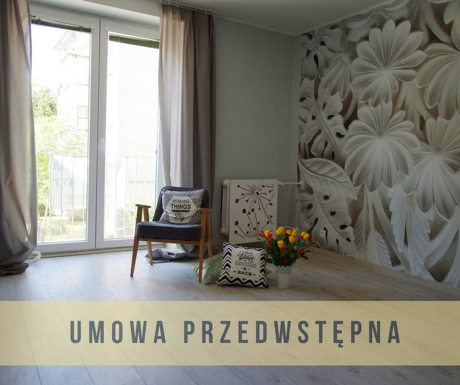 Jasne wnętrze pokoju z fototapetą w kwiaty, drewnianym krzesłem z poduszką, bukietem żółto-czerwonych kwiatów i grzejnikiem dekoracyjnym z motywem dmuchawca.