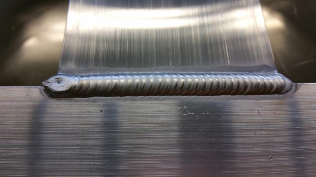 Detal spoiny aluminium z widocznymi śladami obróbki szczotkowanej na powierzchni materiału.