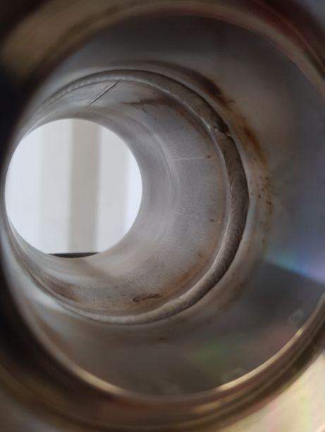 Wnętrze rury ze stali nierdzewnej z widocznym spoiwem spawalniczym i przebarwieniami termicznymi.