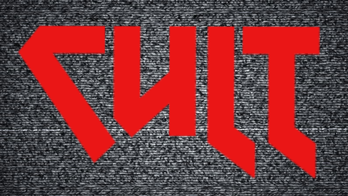 Czerwony napis 'SUIT' na szarym tle przypominającym zakłócenia telewizyjne.