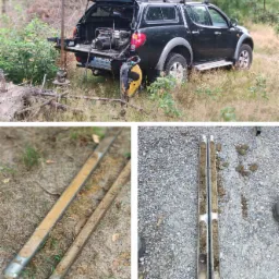 Czarny pickup z otwartą paką, w której znajduje się agregat prądotwórczy, obok wiertnica. Na dole próbki gruntu w metalowych rdzeniach, widoczne warstwy ziemi.