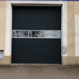 Ciemnoszara segmentowa brama garażowa z trzema poziomymi oknami z refleksami otoczenia, zamontowana w budynku stacji kontroli pojazdów.