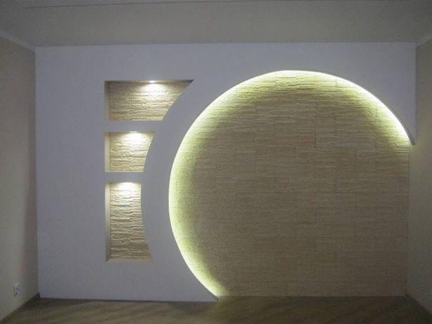 Wykończona ściana z dekoracyjną wnęką z oświetleniem LED w kształcie półkola oraz pionowymi wnękami z fakturą kamienia dekoracyjnego