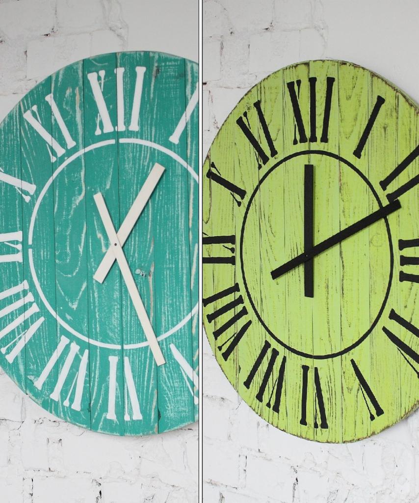 Dwa okrągłe, drewniane zegary ścienne w stylu vintage: turkusowy z białymi wskazówkami i limonkowy z czarnymi wskazówkami, oba z rzymskimi cyframi, wiszące na białej ceglanej ścianie.
