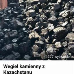Góra węgla kamiennego o nieregularnych bryłach, sfotografowana z bliska, z widoczną strukturą i połyskiem poszczególnych kawałków.