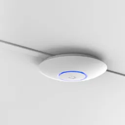 Płaski, okrągły, biały punkt dostępowy Wi-Fi zamontowany na białym suficie, z subtelnym niebieskim podświetleniem pierścieniowym.