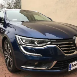 Błyszczący, granatowy Renault Talisman kombi po detailingu, zaparkowany na kostce brukowej. Widoczne chromowane elementy i tablica rejestracyjna 'Beauty Car'.