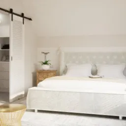 Jasna sypialnia w stylu minimalistycznym z łóżkiem z pikowanym zagłówkiem, szafkami nocnymi z drewna, przesuwnymi drzwiami do garderoby i złotym stolikiem pomocniczym.